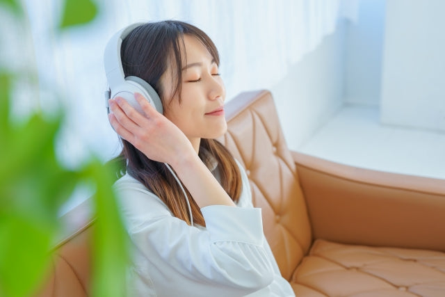 A girl is relaxing and listening to music with headphones