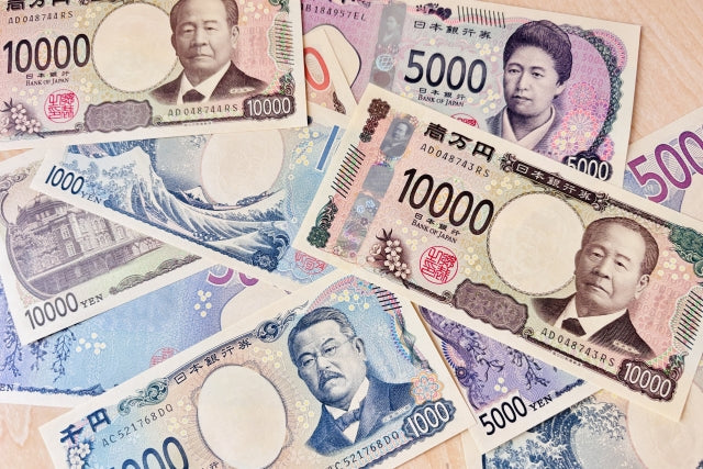 The artwork of the front and back of the new F series paper bills for Japan's yen, issued in 2024, are displayed on a table.