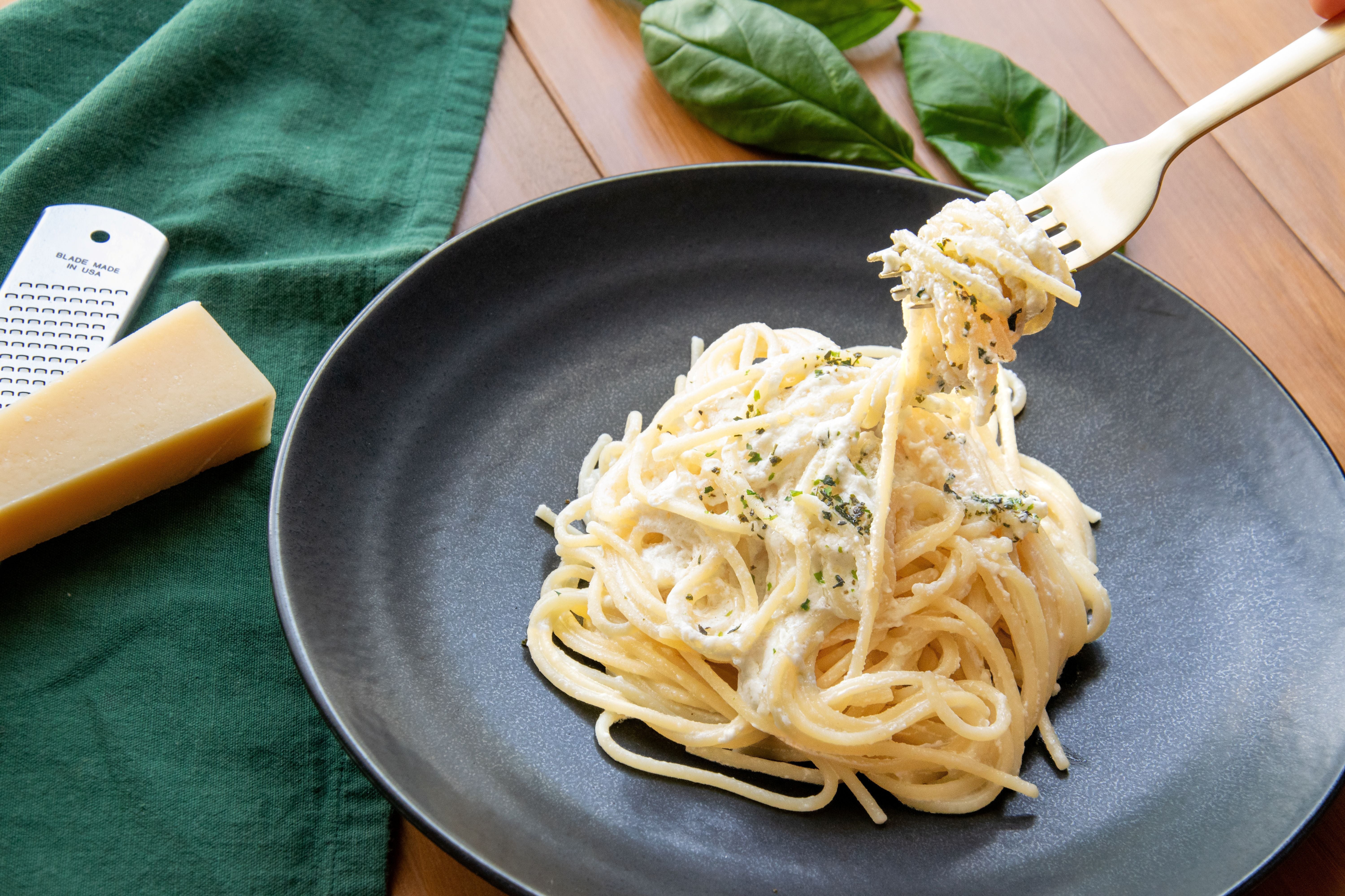 Recipe: Quick & Creamy Tea Leaf Furikake Pasta (plated alongside fresh herbs and grated parmesan cheese)