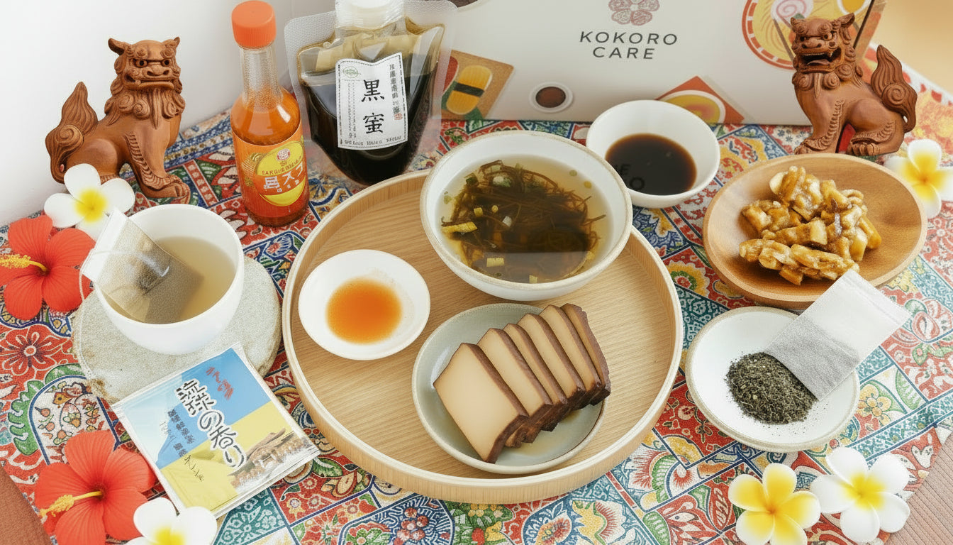 Japanese (Okinawa) food and drink set on a colorful tablecloth with 'Kokoro Care' box in the background.